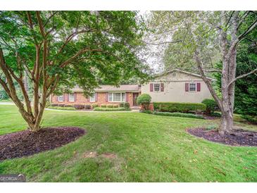 Charming brick home with well-maintained lawn, mature trees, and manicured landscaping at 3170 Ebenezer Rd, Marietta, GA 30066