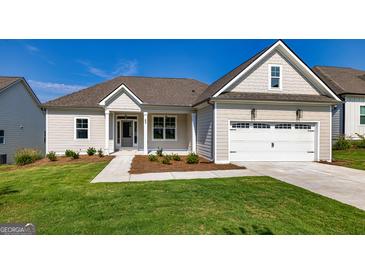 Craftsman style home with a two-car garage and nicely landscaped lawn at 65 Oakhurst Trl, Sharpsburg, GA 30277