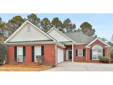 Charming brick home with black shutters, attached garage, and well-maintained front yard at 110 Cloverwood Dr, Fayetteville, GA 30215