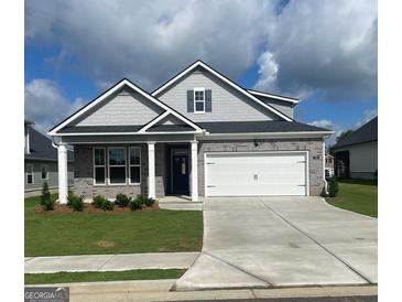 Charming one-story home featuring a gray brick facade, white garage door, and manicured lawn at 753 Myrica Ave, Locust Grove, GA 30248