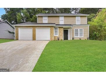 Two-story house with a two-car garage and well-manicured lawn at 3880 Springleaf Ct, Stone Mountain, GA 30083