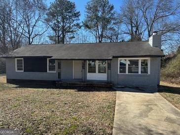 Newly painted gray house with a paved driveway and mature trees at 285 Queen Helen Ln, Jonesboro, GA 30236