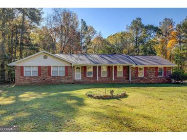 Brick ranch house with a large front yard and mature trees at 155 Island Shoals Rd, Covington, GA 30016