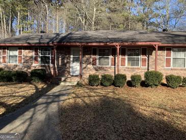 Brick ranch house with covered porch, landscaping, and a walkway at 10100 Silent Trl, Jonesboro, GA 30238