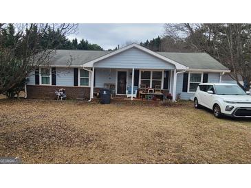 Ranch style home with covered porch and mature trees in the front yard at 614 Strickland Rd, Locust Grove, GA 30248