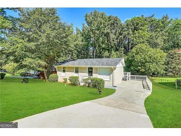 Ranch style home with a large yard and driveway at 3961 Cornell Sw Blvd, Atlanta, GA 30331