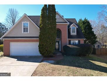 Two-story brick home with a large driveway and landscaping at 404 Big Leaf Walk, Mcdonough, GA 30253