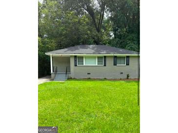 Charming single-story home with green lawn, neutral brick and welcoming front porch at 752 Jefferson Sw Ave, Atlanta, GA 30315