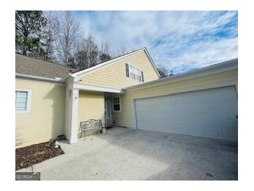 Inviting exterior featuring a two-car garage and charming front porch at 144 Cottsford Sw Dr # 22, South Fulton, GA 30331