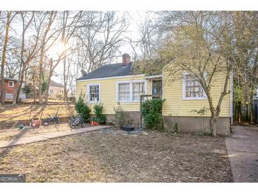Ranch style home with yellow siding and a small yard at 1826 E Farris Ave, East Point, GA 30344