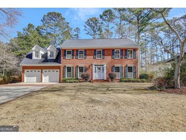 Brick two-story house with two-car garage and landscaping at 131 Cloister Dr, Peachtree City, GA 30269