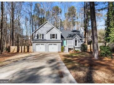 Two-story house with gray siding, three-car garage, and landscaped yard at 118 Michael Ct, Dallas, GA 30157