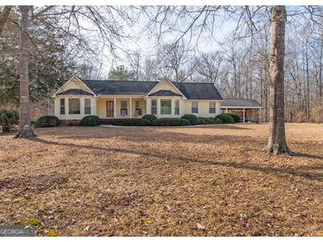 Ranch style home with large yard, covered porch, and mature trees at 130 Seneca Pl, Fayetteville, GA 30215