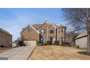 Charming brick home featuring a manicured lawn and attached two-car garage at 301 Dunstans Pass, Marietta, GA 30066
