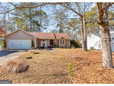 Tan house with two car garage and landscaping at 5899 Meadow Ln, Rex, GA 30273