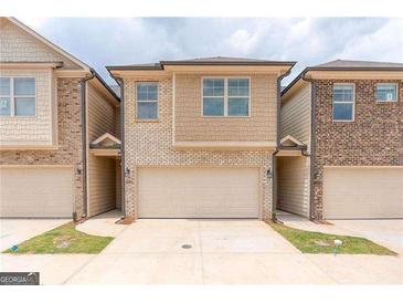 Two-story townhome with attached garage and neutral color brick exterior at 4121 Fulson Dr, Lilburn, GA 30047