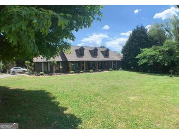 Charming home with a well-manicured lawn, mature trees, and inviting front porch at 3919 Evans Rd, Cumming, GA 30040