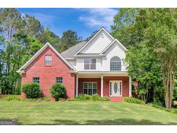 Charming two-story brick home featuring a well-maintained lawn and inviting front porch at 90 Barrington Grange Dr, Sharpsburg, GA 30277