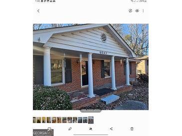 Brick ranch house with covered porch and columns at 6045 Winview Dr, Forest Park, GA 30297