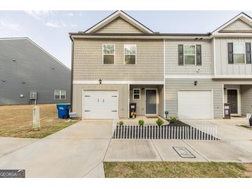 Two-story townhome with gray siding, white garage door, and small front yard at 4937 Lower Elm St, South Fulton, GA 30349