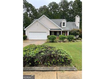 Brick and beige two-story house with a two-car garage and well-manicured lawn at 161 Revolutionary Dr, Hampton, GA 30228