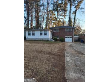 Cozy two-story home with a brick facade and a one-car garage, situated in a wooded area at 2537 Fontaine Cir, Decatur, GA 30032