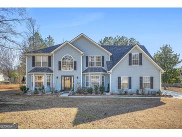 Two story house with blue siding, large windows, and a grassy yard at 2040 Winding Crossing Trl # 1, Fairburn, GA 30213