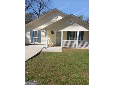 Cute yellow house with teal shutters, white porch, and a well-maintained lawn at 1059 Garibaldi Sw St, Atlanta, GA 30310
