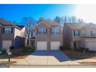 Two-story brick home with two-car garage and landscaping at 11958 Quail Dr, Hampton, GA 30228