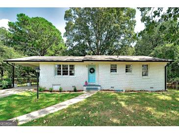 Charming ranch home with white brick exterior, landscaped lawn, and a light blue front door at 287 Decatur Rd, Mcdonough, GA 30253