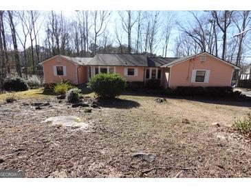Ranch home with neutral siding, white trim, and a yard with mature shrubs and trees at 125 Oak Leaf Dr, Stockbridge, GA 30281