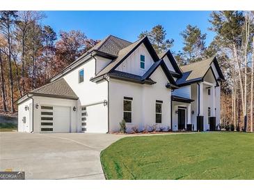 Stunning two-story home boasting a white brick facade, sleek black trim, and a modern garage door design at 1010 Nours Cir, Lawrenceville, GA 30045