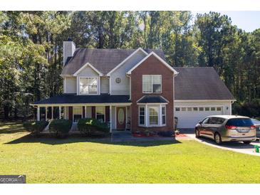 Two-story brick home with a covered porch and attached garage at 245 Mckenzie Dr, Stockbridge, GA 30281
