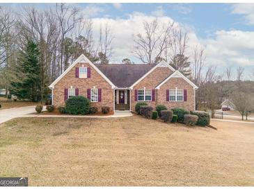 Brick house with landscaped yard and driveway at 443 Abbey Pl, Villa Rica, GA 30180