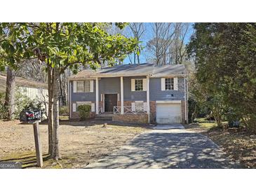 Ranch style home with gray siding, brick accents, and a two-car garage at 6665 Cedar Hurst Trl, College Park, GA 30349