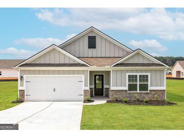 Newly constructed craftsman style home with a two-car garage and landscaped lawn at 445 Prescott Way, Villa Rica, GA 30180