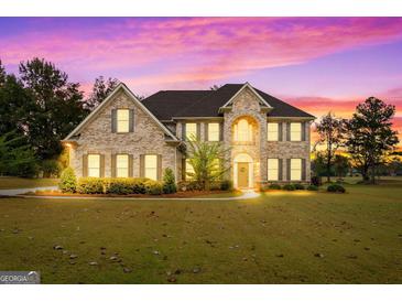Two-story brick home with a welcoming front porch and landscaped lawn at 870 N Bethany Rd, Mcdonough, GA 30252