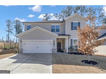 Charming two-story home with a well-maintained lawn and a two-car garage and a lovely dormant tree at 720 Lanarck Way, Peachtree City, GA 30269