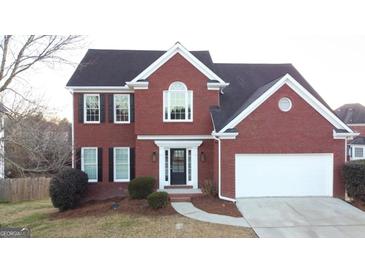 Charming two-story brick home featuring a well-manicured lawn, black shutters and a two-car garage at 3226 Masters Pass Ln, Snellville, GA 30039