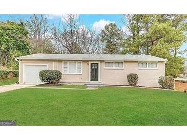 Ranch style home with a well-maintained lawn and attached garage at 348 Cologne Se Dr, Atlanta, GA 30354