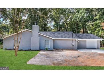 Newly renovated house with gray siding, a two-car garage, and a spacious front yard at 1351 Renee Dr, Decatur, GA 30035