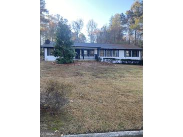 Ranch style home with white exterior and landscaping at 7280 Oswego Trl, Riverdale, GA 30296