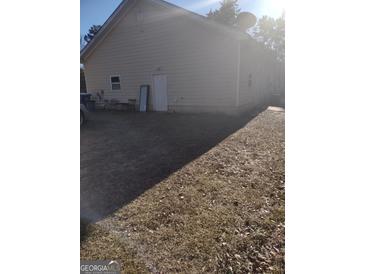Tan house exterior with a detached garage and yard at 4031 S Old Fairburn Road S Rd, South Fulton, GA 30349