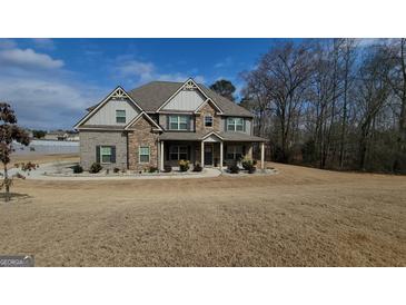 Beautiful two-story home featuring a well-manicured front yard and a charming covered porch entrance at 128 Lavender Way # 75, Mcdonough, GA 30252