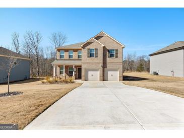 Beautiful brick two-story home with a two-car garage and well-maintained lawn at 755 Gelderland Dr, Hampton, GA 30228