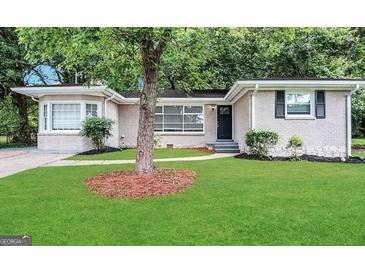 Charming single-story home with a well-maintained lawn and a classic brick facade, nestled among mature trees at 3376 Brookfield Ln, Decatur, GA 30032