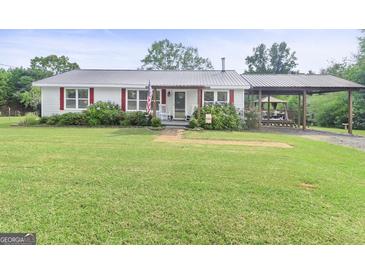 Charming one-story home featuring a metal roof, a cozy front porch and covered carport at 382 Lamb Rd, Moreland, GA 30259