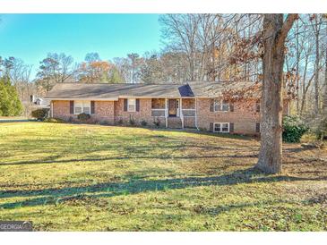 Charming brick home with a lush front yard, welcoming stone accents, and a cozy front porch at 185 Redwood Cir, Fayetteville, GA 30214