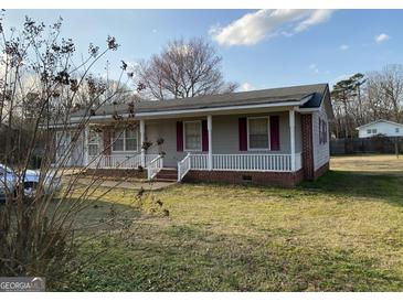 Charming single-story home with a cozy front porch and well-maintained lawn at 376 Lakewood Dr, Social Circle, GA 30025