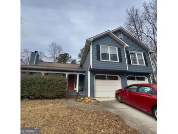 Charming two-story home with blue siding, white trim, two-car garage, and a well-manicured front yard at 3415 Camens Ct, Buford, GA 30519